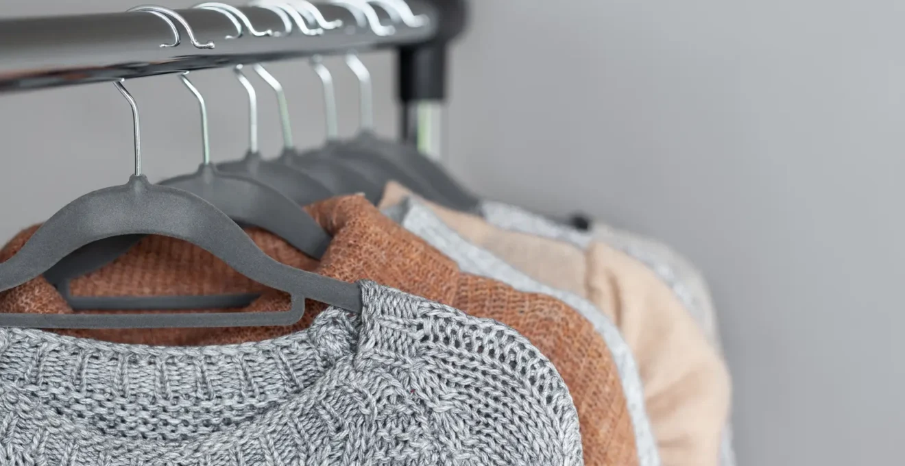 Inspection minutieuse des finitions d'un tricot français montrant la qualité d'assemblage des bordures